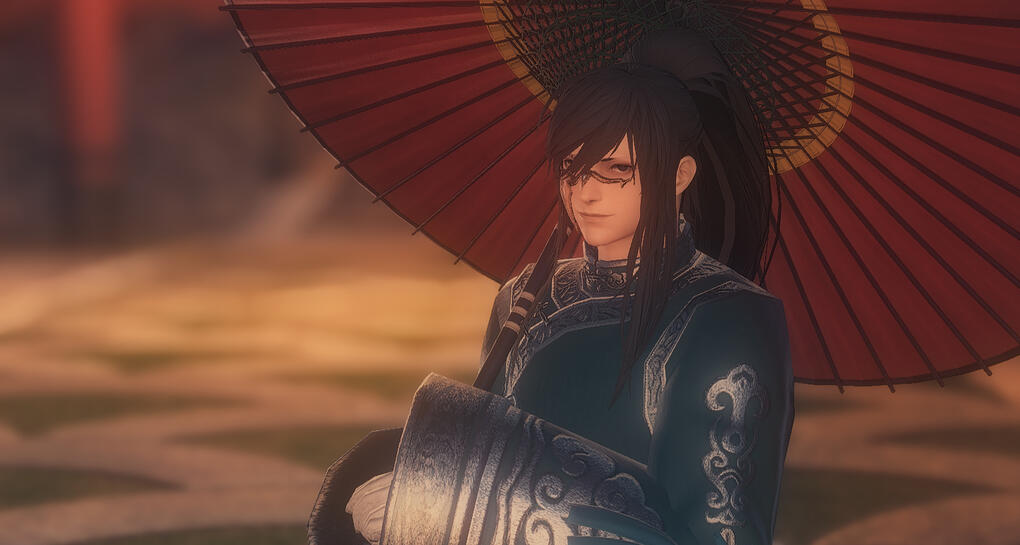 A young adult Hingan man dressed in traditional garb and carrying a paper parasol.